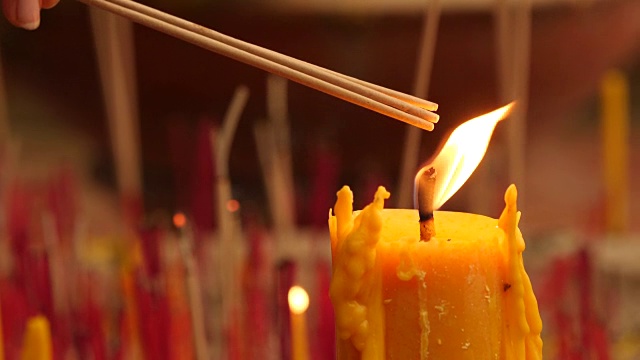 祈祷者点燃香烛，蜡烛上放一根蜡烛火，靠近。视频素材
