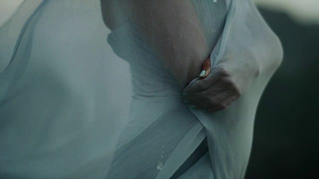 浪漫的女孩穿着长裙享受着风。藏在透明的纺织品里视频素材
