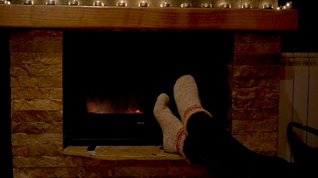 女孩的脚在壁炉前暖着。视频素材