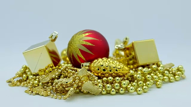 金色的圣诞装饰和红色的球与星星旋转在白色的背景。视频素材
