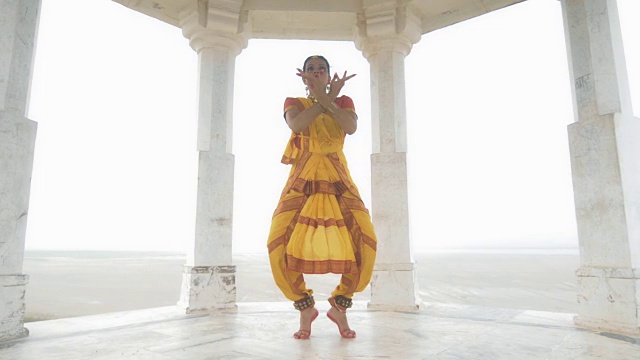 一个迷人的女人或女士在黄色传统纱丽做手势的动人镜头视频下载