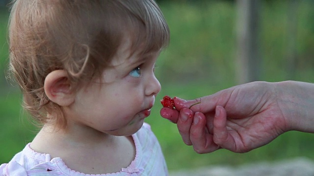 婴儿从母亲手中吃草莓的特写视频下载