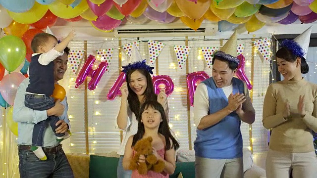一群年轻的亚洲家庭一起跳舞在派对活动在家里。全家欢度除夕。视频购买