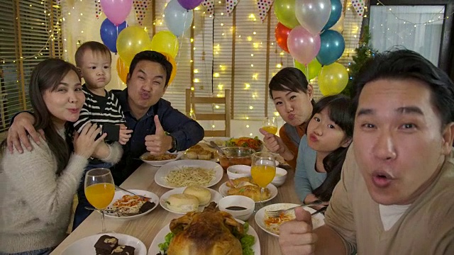 快乐的亚洲家庭在聚会上自拍。快乐的朋友在家里一起享受圣诞晚餐。视频下载