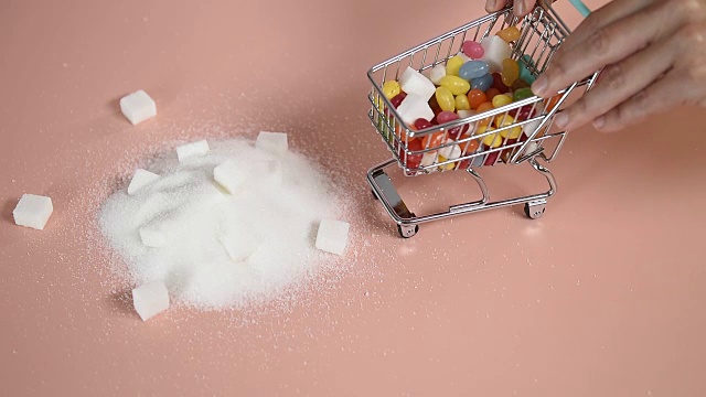 玩具购物车在糖堆上倾倒糖果视频素材