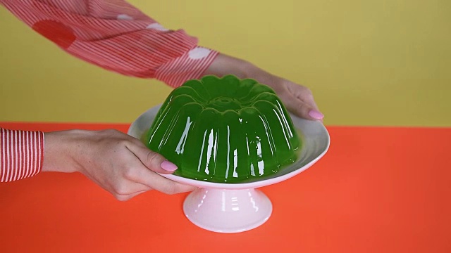 双手在蛋糕架上摇摆着绿色果冻视频素材