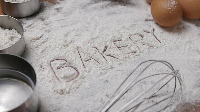 糕点烘焙配件面包房背景与面包房文字写在面粉上。烘焙制品制备用配料。视频下载