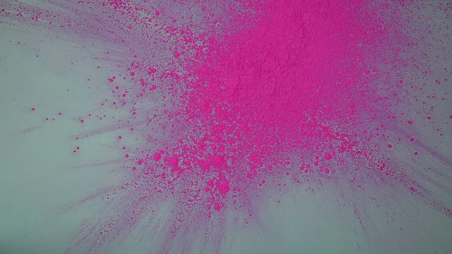 粉红色的粉末溅落在蓝色的纸上视频素材