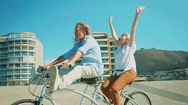 老年夫妇在夏天享受双人自行车视频素材
