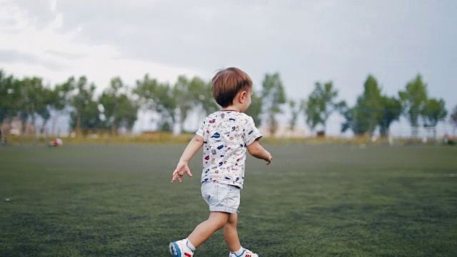 不明身份的孩子在日落的背景下踢足球。缓慢的运动。视频素材
