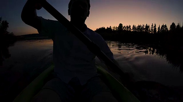 皮划艇日落剪影的人划桨下的月亮视频素材