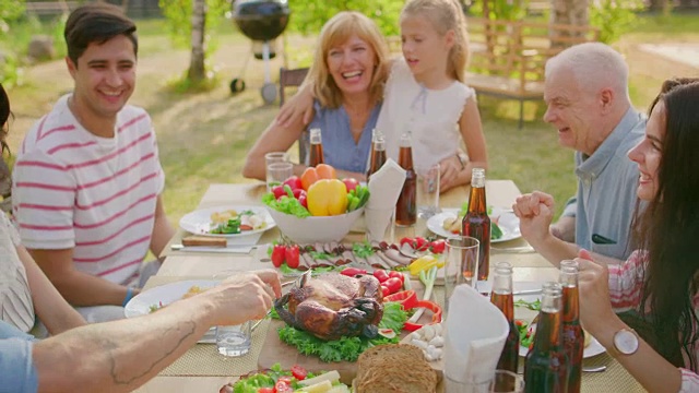 大型家庭花园聚会庆祝，聚在桌子上，吃，开玩笑，玩。滑球越过桌子。视频素材