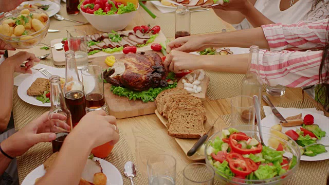 从上到下的移动镜头:大型家庭花园聚会庆典，人们吃，喝，传递菜肴。假日乐趣在一个阳光明媚的夏天。缓慢的运动。视频素材