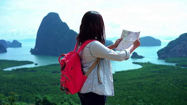 迷人的亚洲女性旅行者寻找旅游地图的方向和寻找目的地在山在samenang Chee，自然旅行和冒险徒步概念的4k视频场景视频素材