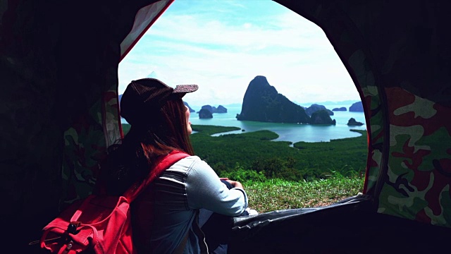 迷人的亚洲女游客坐在帐篷里看山，感受自由和享受自然的4K慢镜头，在samenang Chee，旅行和幸福的生活理念视频素材