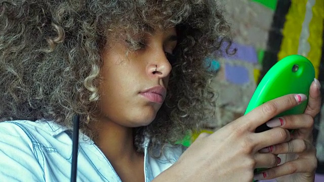 非裔美国女孩在咖啡馆用智能手机视频素材