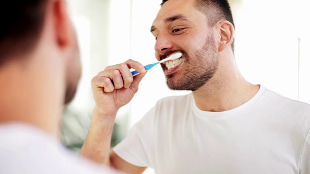 拿着牙刷在浴室刷牙的男人视频素材