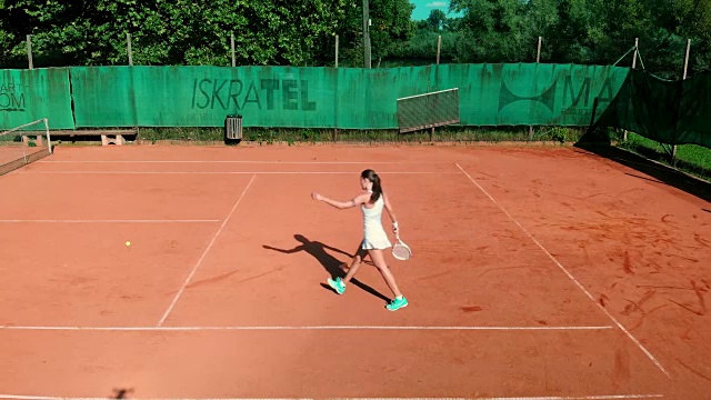 一个迷人的成熟女子打网球在白色运动服视频素材