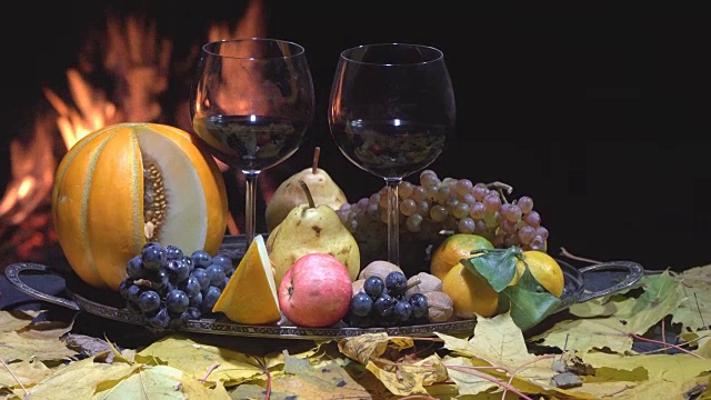 两杯葡萄酒，奶酪，面包和水果，在火背景，摄影视频素材