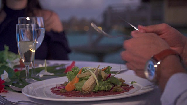 一对男女在热带岛屿度假胜地外面用餐。视频素材