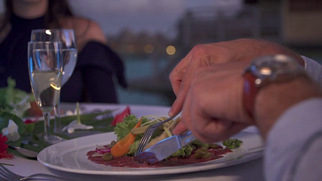 一对男女在热带岛屿度假胜地外面用餐。视频素材