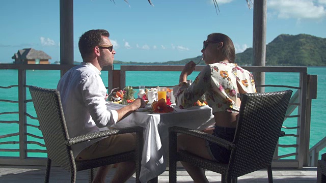 一对男女在热带岛屿度假胜地外面吃早餐。视频素材