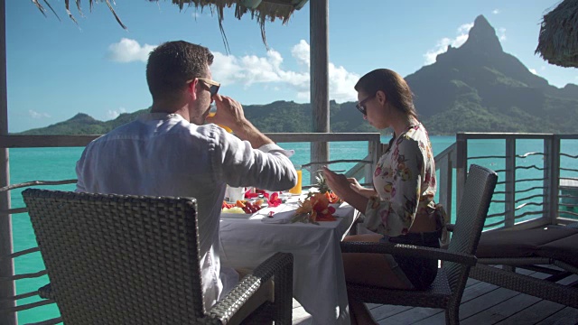 一对男女在热带岛屿度假胜地外面吃早餐。视频素材