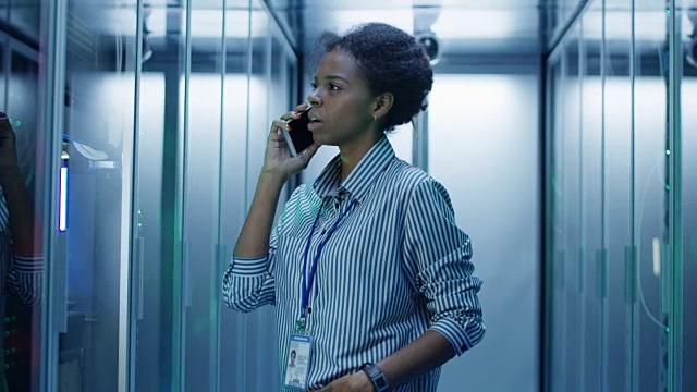 一个黑人女人在服务器室打电话视频素材