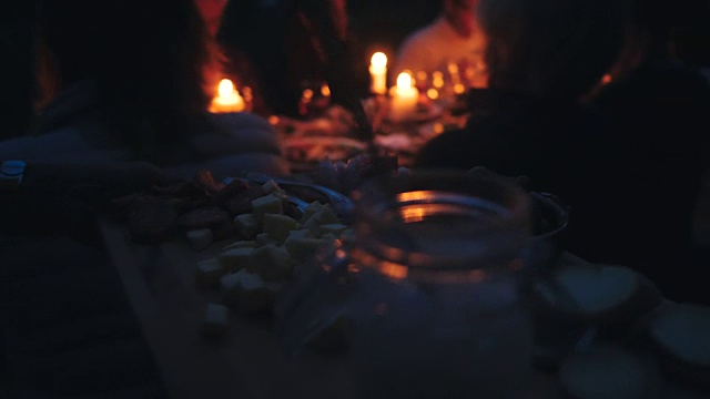 在后院的收获晚宴上，一名妇女在餐桌上拿着砧板上的食物走向朋友视频素材