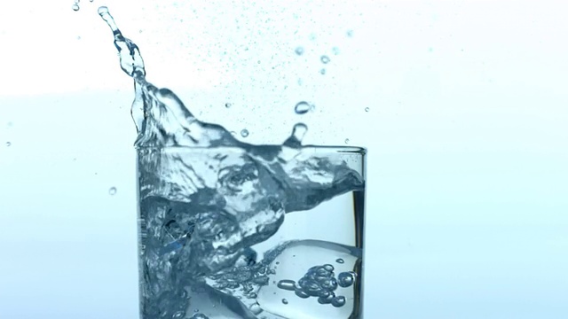 冰块溅到一杯水中视频素材