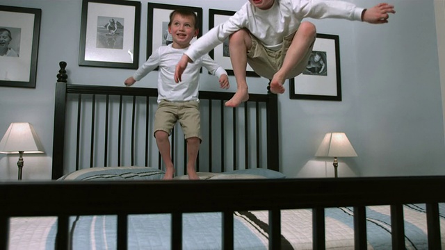 两个男孩在床上跳，慢镜头视频素材