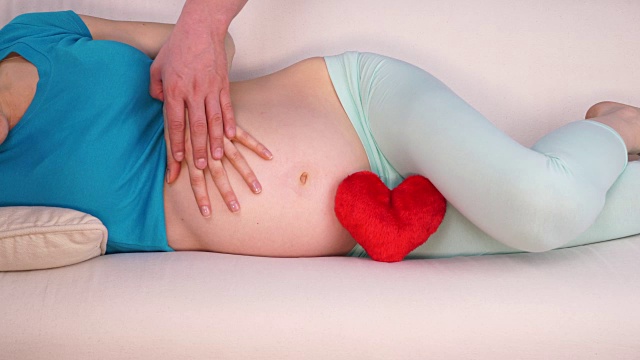 一对期待宝宝的夫妇，他们的手触摸着怀孕的腹部4K视频素材
