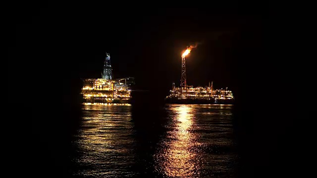 夜间靠近石油平台平台的FPSO油轮。海上石油和天然气工业视频素材
