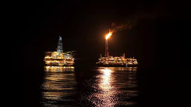 夜间靠近石油平台平台的FPSO油轮。海上石油和天然气工业视频素材