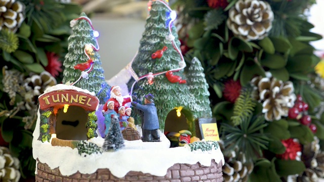 用运动中的火车照亮雪村玩具的节日装饰。平面视频下载