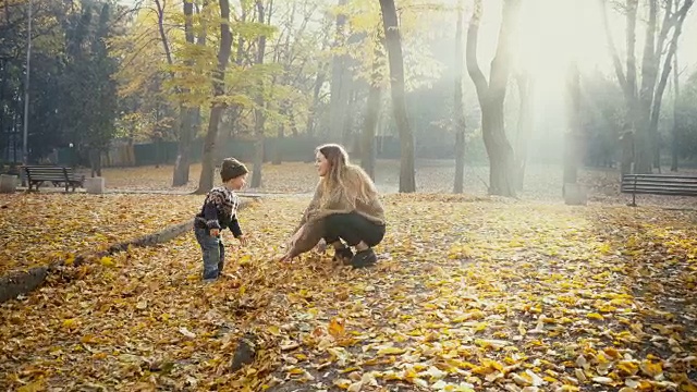 秋天，妈妈和小儿子在公园里玩视频素材