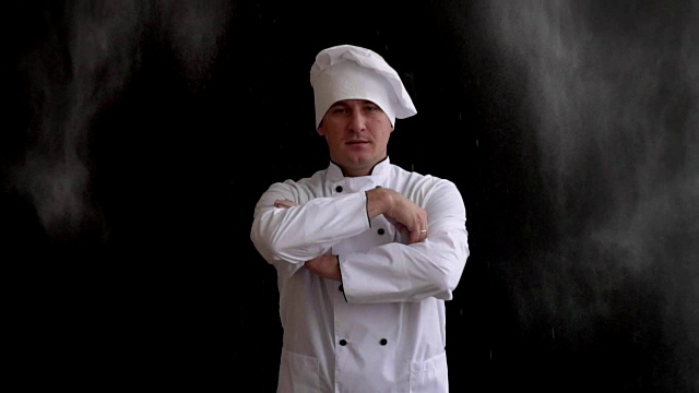 成年厨师穿着白色西装，戴着黑色背景的帽子视频下载