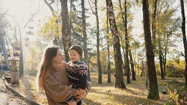 秋天，母亲在公园里牵着儿子的手视频素材