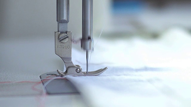 缝纫机的工作宏观细节。针移动并缝合织物。在纺织厂裁剪这种材料视频素材