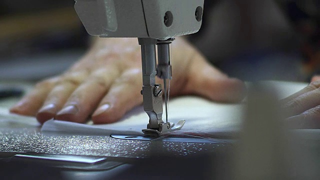 缝纫机的工作宏观细节。针移动并缝合织物。在纺织厂裁剪这种材料视频素材