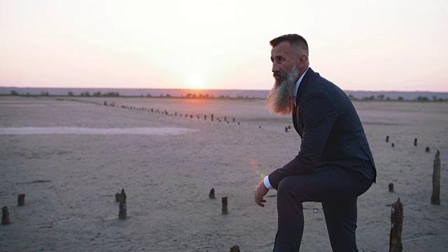 英俊的胡子成熟的男人在户外海滩在日落，慢动作视频下载