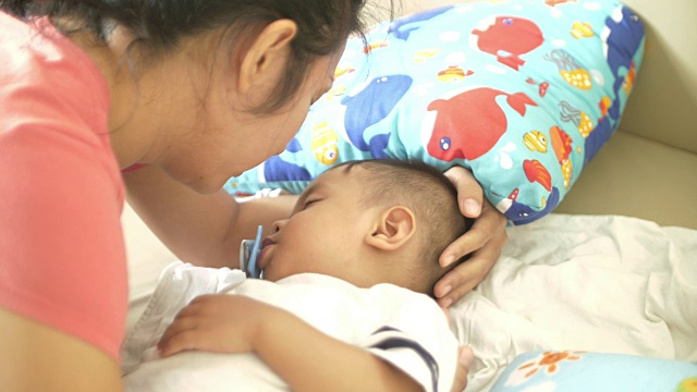 妈妈看着熟睡的婴儿，亲吻着视频素材