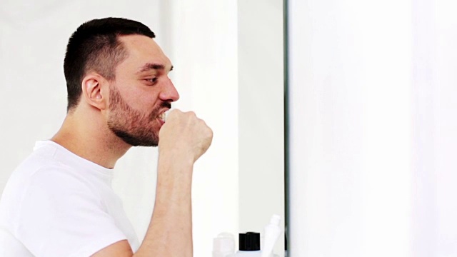 拿着牙刷在浴室刷牙的男人视频素材