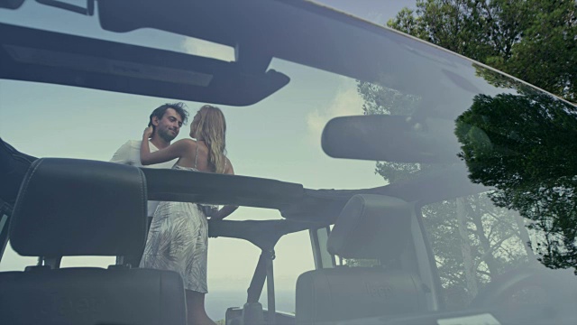 浪漫的情侣在敞篷的SUV中拥抱。的观点视频素材