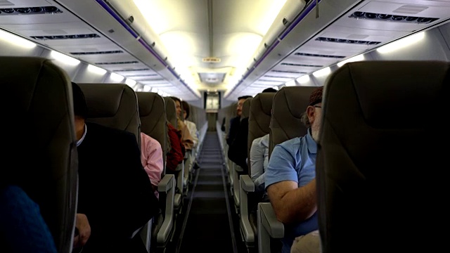 在商业航班上，人们有的在聊天，有的在放松视频下载