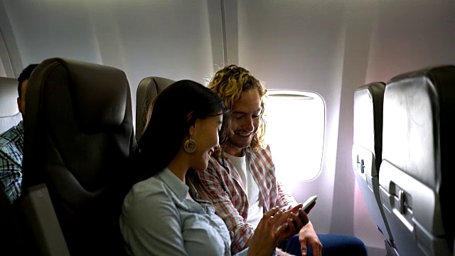 一对美丽的年轻夫妇在飞机上自拍，两人都微笑着视频素材
