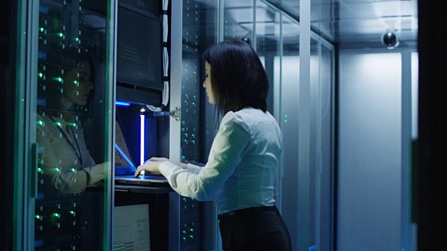一名女性技术员在数据中心的笔记本电脑上工作视频下载