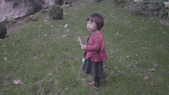 小女孩在春天的花园里玩泡泡视频素材