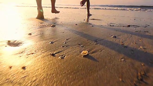 幸福的家庭母亲和女儿在日落的海滩上，慢镜头视频素材