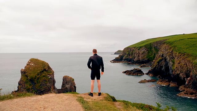 一个人站在悬崖上在一个微风的日子4k视频素材